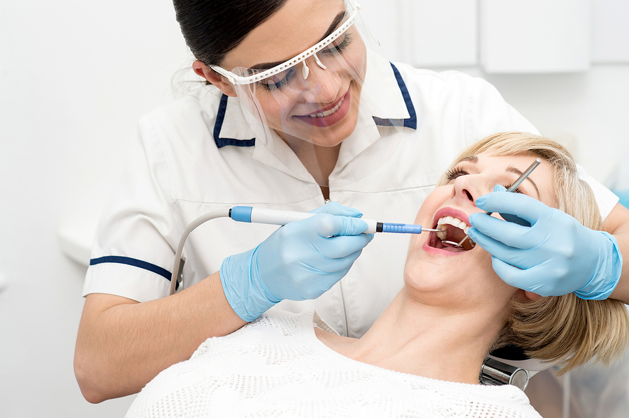 dentist checking womans teeth