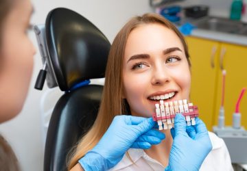 Dentist selects a shade of teeth veneers